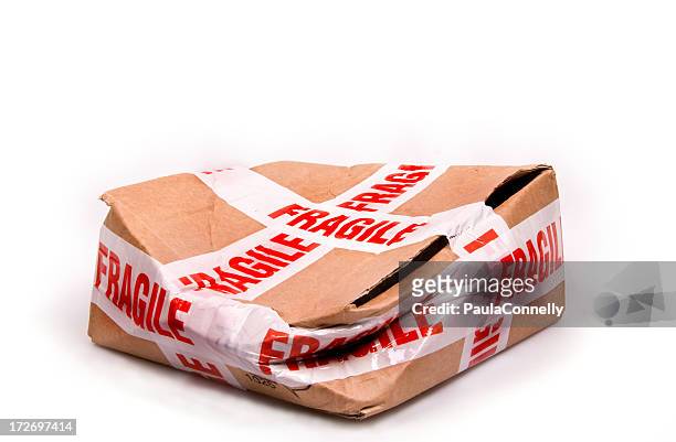 a smashed box with fragile tape all around it - breekbaarheid stockfoto's en -beelden