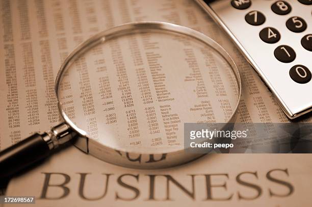 financial series - magnifying glass newspaper watching finance stock market and exchange stock pictures, royalty-free photos & images