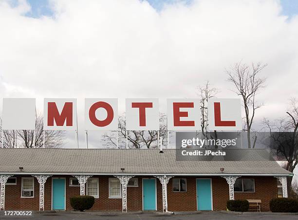 retro red lettered motel sign on top of building - motel stockfoto's en -beelden