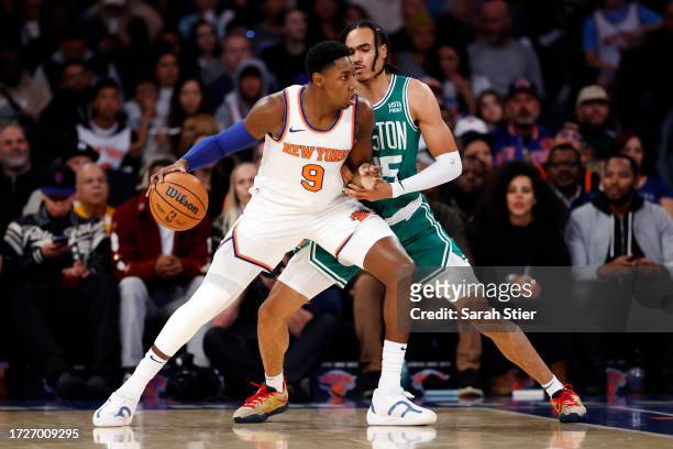 Barrett of the New York Knicks dribbles as Dalano Banton of the Boston Celtics defends during the first half of a preseason game at Madison Square...