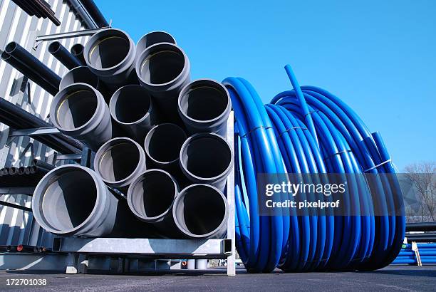 gigantic pvc pipes and tubings outside warehouse - pvc stockfoto's en -beelden