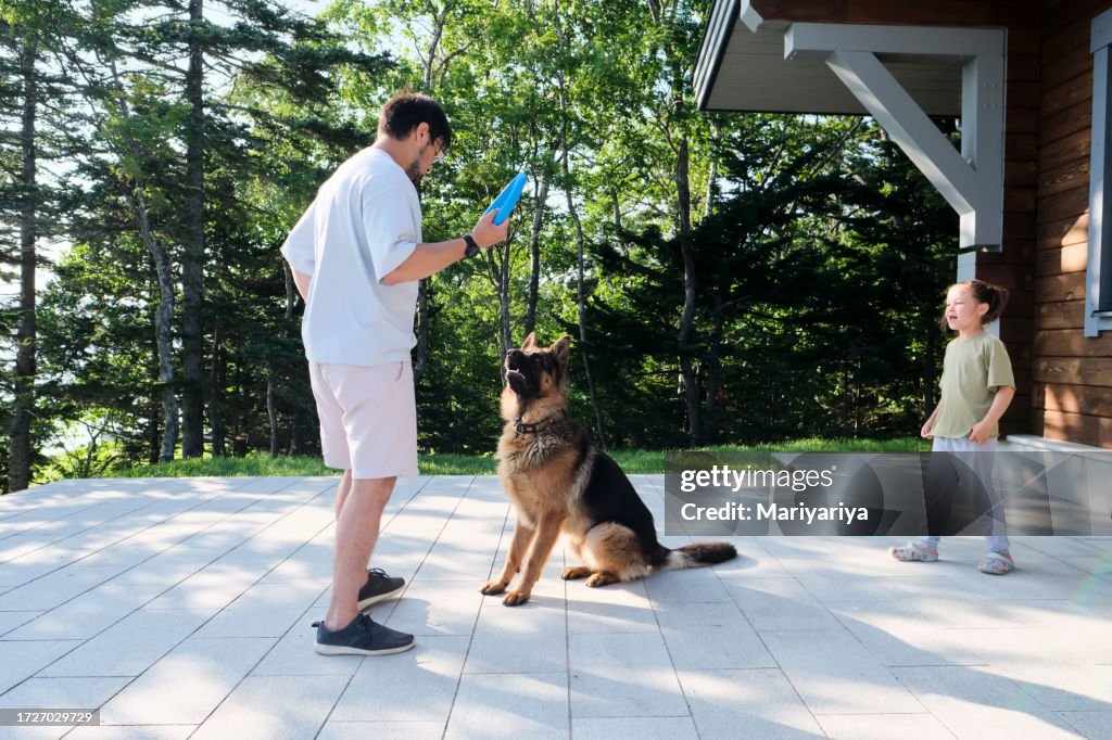 A man trains a dog using a ring.