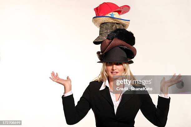 business woman balancing life having to wear too many hats - menselijke rol stockfoto's en -beelden