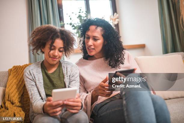 technologie und zusammengehörigkeit: hispanische mutter und gemischtrassige tochter - kind vor der pubertät stock-fotos und bilder