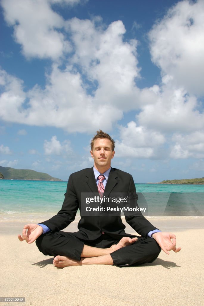 Homme d'affaires faisant Yoga sur la plage tropicale