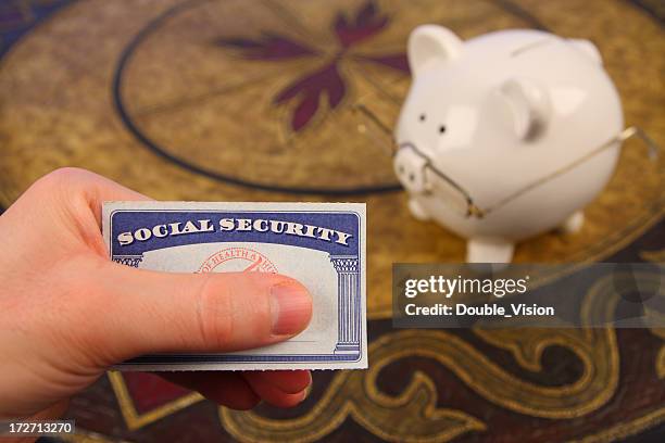 retirement savings: social security card and piggy bank with spectacles - social security kaart stockfoto's en -beelden