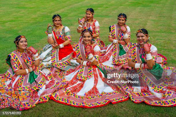 People dressed in colorful and ornate traditional Indian ethnic outfits gather to worship and later participate in dance events as they practice the...