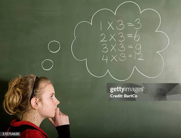 mädchen ist die lösung eines mathematische problem auf tafel - multiplizieren stock-fotos und bilder