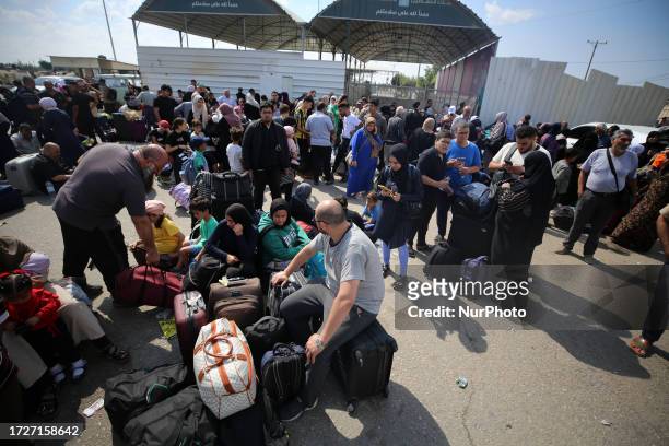 Palestinians, some with foreign passports hoping to cross into Egypt and others waiting for aid wait at the Rafah crossing in the southern Gaza...
