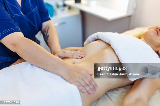 professional abdominal massage therapist conducts abdominal massage with purpose of enhancing detoxification and lymphatic drainage - lymphatic system stock pictures, royalty-free photos & images