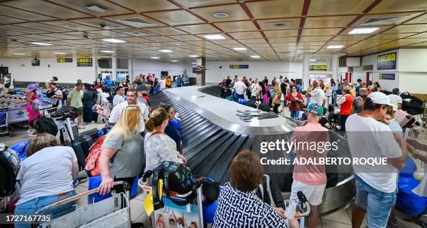 Passengers wait for their luggage at Havana's Jose Marti airport on October 12, 2023.