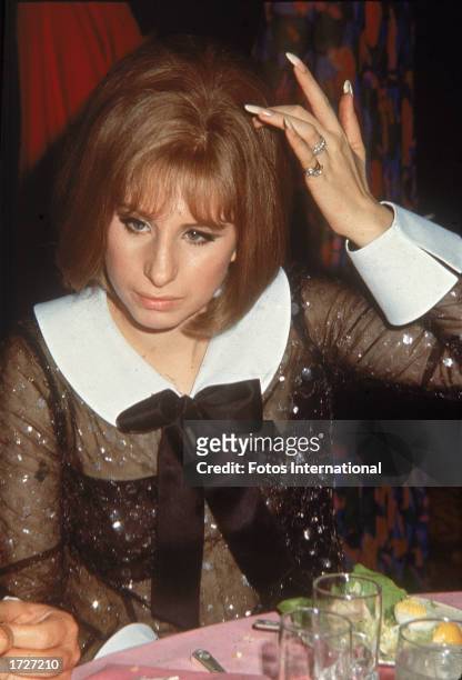 American singer and actor Barbra Streisand sits at a table during the Academy Awards, Dorothy Chandler Pavilion, L.A. County Music Center, Los...