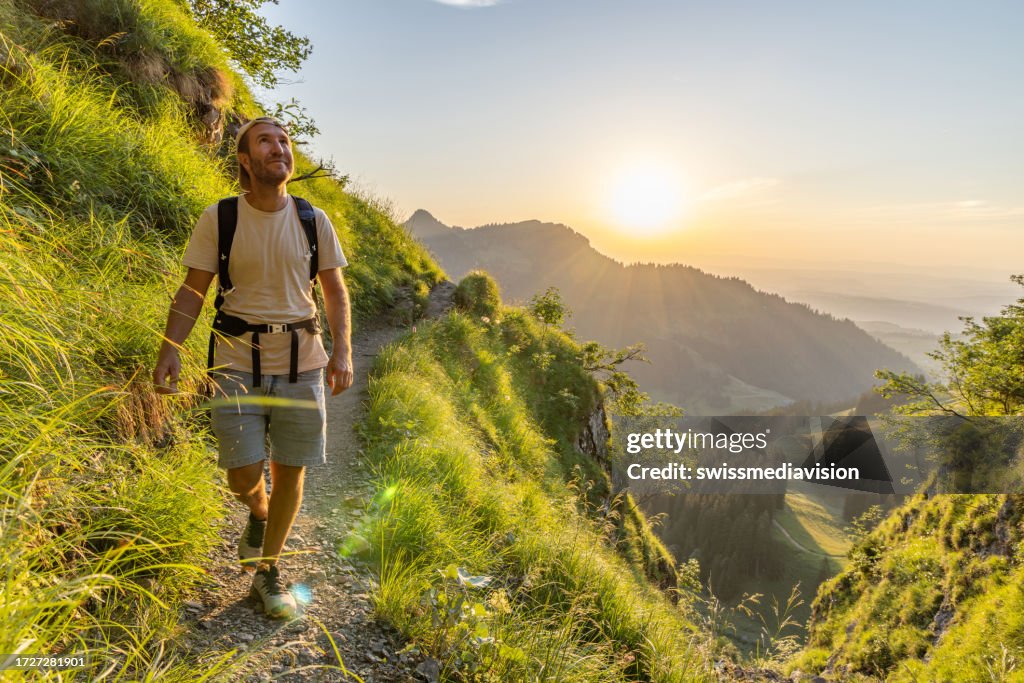 Escursionista si rilassa sulla cresta di montagna soleggiata