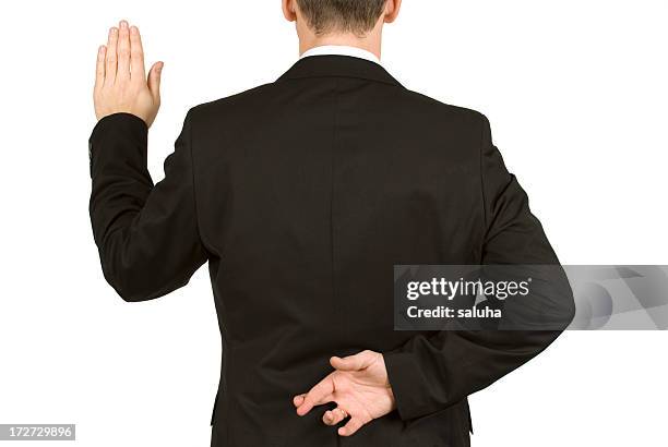 man in suit taking oath while crossing fingers behind back - pledge stock pictures, royalty-free photos & images