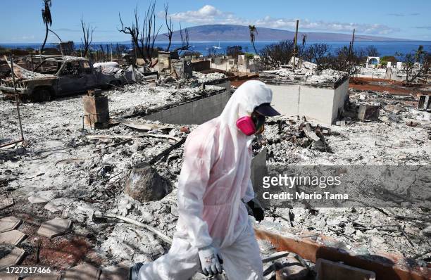 Volunteer from Samaritan's Purse helps a daughter search for family items in the rubble of her mother's wildfire destroyed home on October 09, 2023...