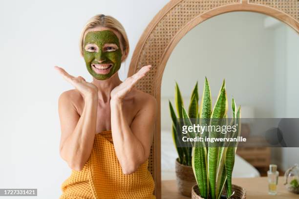 portrait of cheerful woman wearing facial mask - dubai spa stock-fotos und bilder
