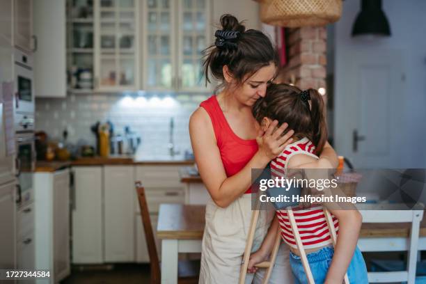 portrait of a young girl with broken leg spending her summer break at home with mother. - krücken stock-fotos und bilder