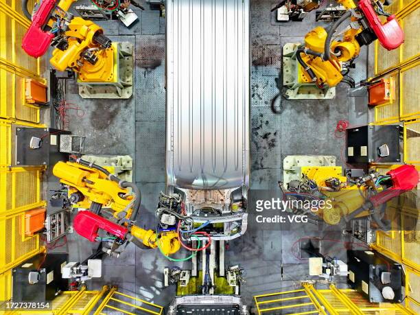 Robotic arms weld parts of electric express delivery vehicles on the assembly line at a factory on October 9, 2023 in Ganzhou, Jiangxi Province of...