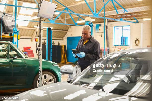 female garage owner doing diagnostics - hand tool stock pictures, royalty-free photos & images
