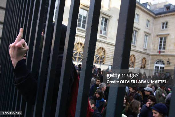 Student shows the finger at the entrance of the College de France, an elite research institution in the capital's Latin Quarter, during a...