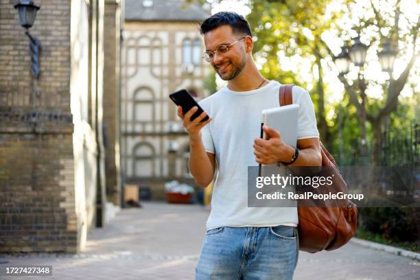 schüler checken nachrichten auf dem smartphone - university students real studying stock-fotos und bilder