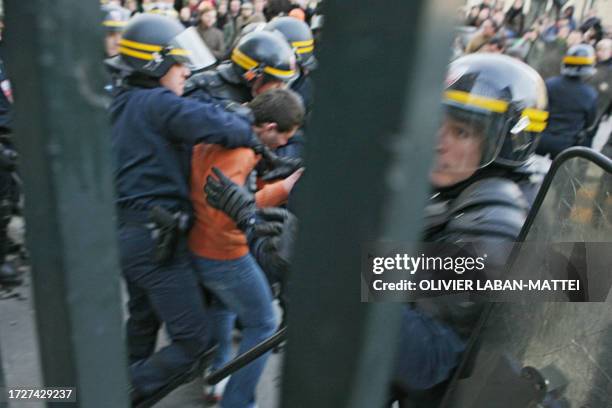 Policemen arrest a student at the entrance of the College de France, an elite research institution in the capital's Latin Quarter, during a...