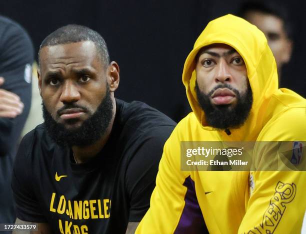 LeBron James and Anthony Davis of the Los Angeles Lakers look on from the bench in the fourth quarter of their preseason game against the Brooklyn...