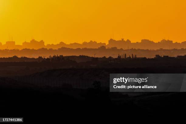 October 2023, Israel, Sderot: A general view of the sunset over Gaza as fighting between Israeli troops and Islamist Hamas militants continues....