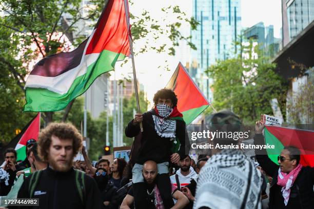 Protestors march while waving the Palestinian flag at a Pro-Palestine rally on October 10, 2023 in Melbourne, Australia. The Palestinian militant...