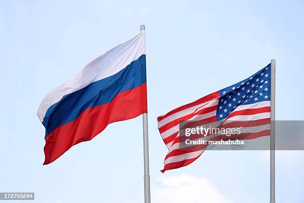 the russian and american flags flying side by side - us russia stock pictures, royalty-free photos & images