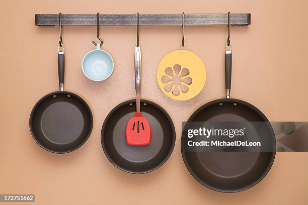 pans and utensils hanging on kitchen wall - cooking pan stock pictures, royalty-free photos & images