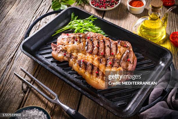 beef rib steak grilled on cast iron grill with herbs olive oil, tomato, pepper ingredients - angus stock pictures, royalty-free photos & images