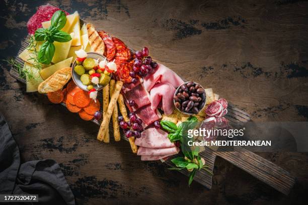 mediterranean appeticer antipasto wooden board, cold cuts meat charcuterie and cheese - charcuterie stock pictures, royalty-free photos & images