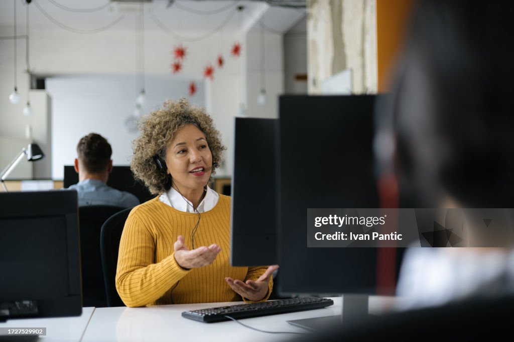 Glückliche Frau, die mit jemandem im IT-Support-Center spricht.