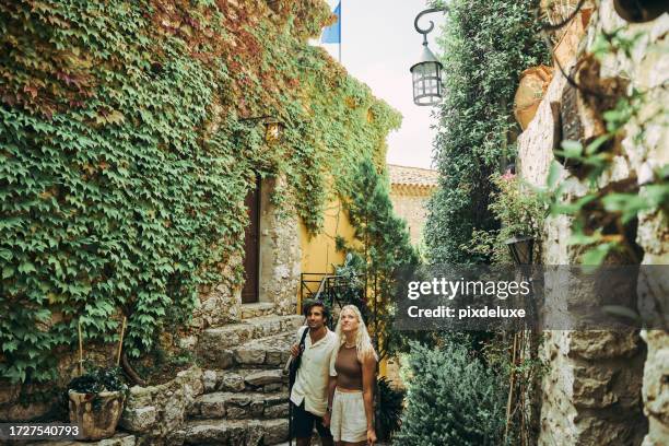happy millennial couple, exploring the historic village of eze in the south of france, while on vacation. - cote dazur stock pictures, royalty-free photos & images