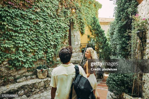 casal millennial feliz, explorando a vila histórica de eze, no sul da frança, durante as férias. - eze village - fotografias e filmes do acervo