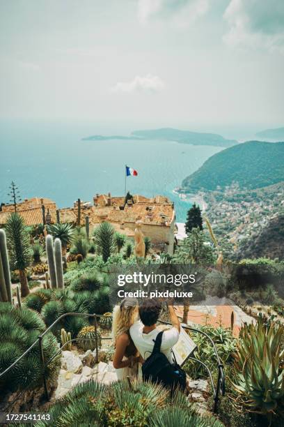 happy millennial couple, exploring the historic village of eze in the south of france, while on vacation. - cote dazur stock pictures, royalty-free photos & images