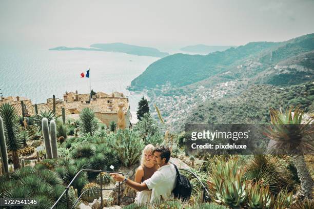 glückliches millennial-paar, das im urlaub das historische dorf eze in südfrankreich erkundet. - eze village stock-fotos und bilder