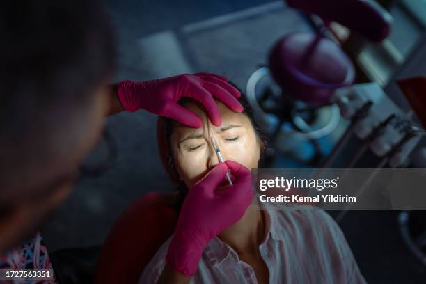 mid adult woman is getting a rejuvenating facial injections at beauty clinic - aesthetic medicine stock pictures, royalty-free photos & images