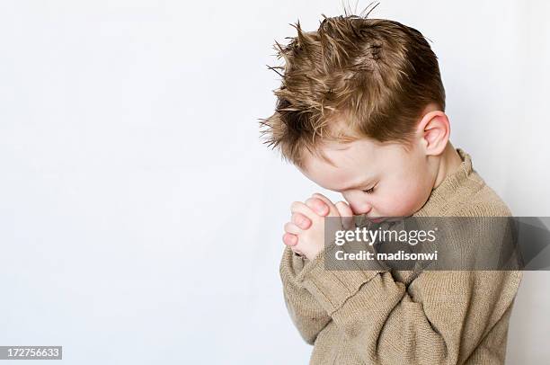 little boy with hands folded and head bowed in prayer - one boy only stock pictures, royalty-free photos & images