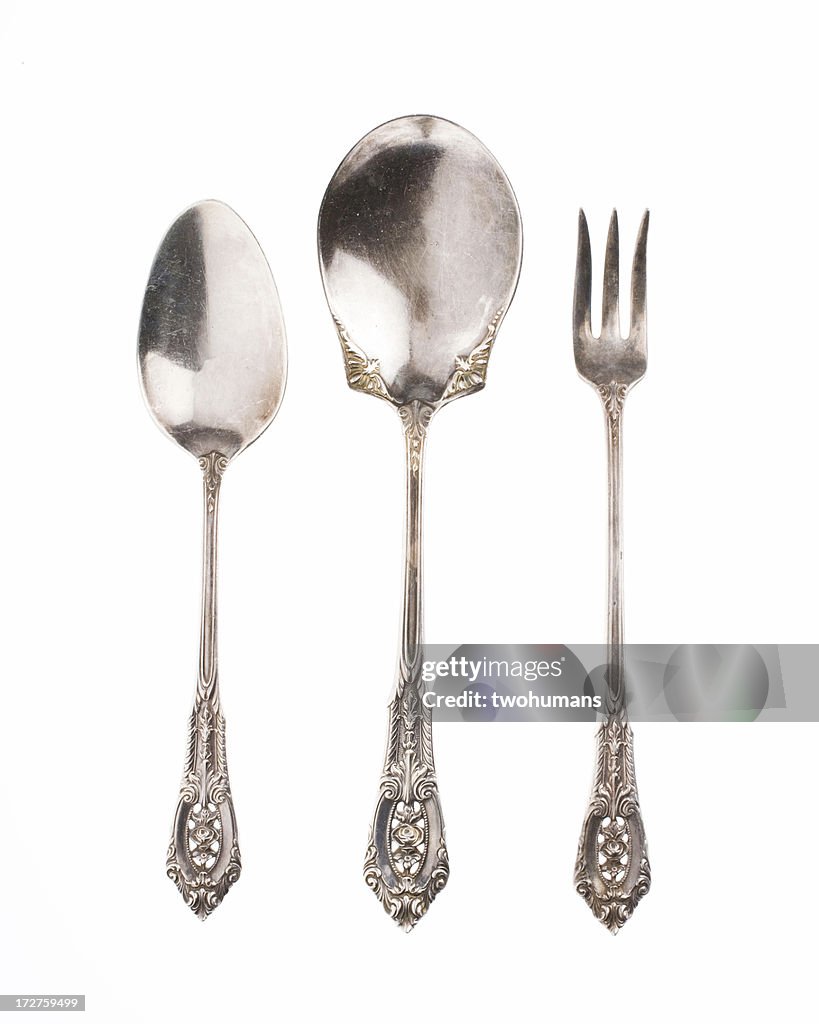Antique silver spoons and fork on white background