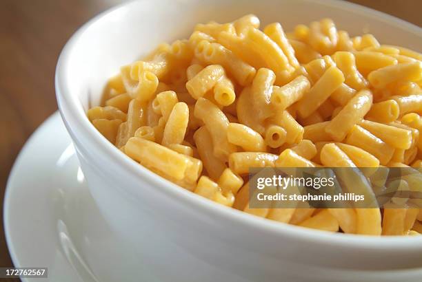 creamy macaroni and cheese in a bowl on a table - macaroni and cheese stockfoto's en -beelden