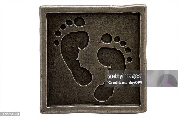 baby füße in metall square - baby fußabdruck stock-fotos und bilder