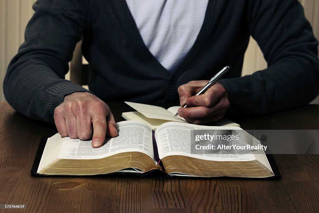 Person studying the Bible with pen and notebook