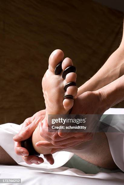 un massage de réflexologie des pieds aux pierres chaudes ii - réflexologie photos et images de collection