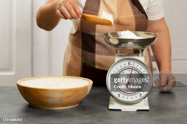 senior woman weighing flour - kitchen scale stock pictures, royalty-free photos & images