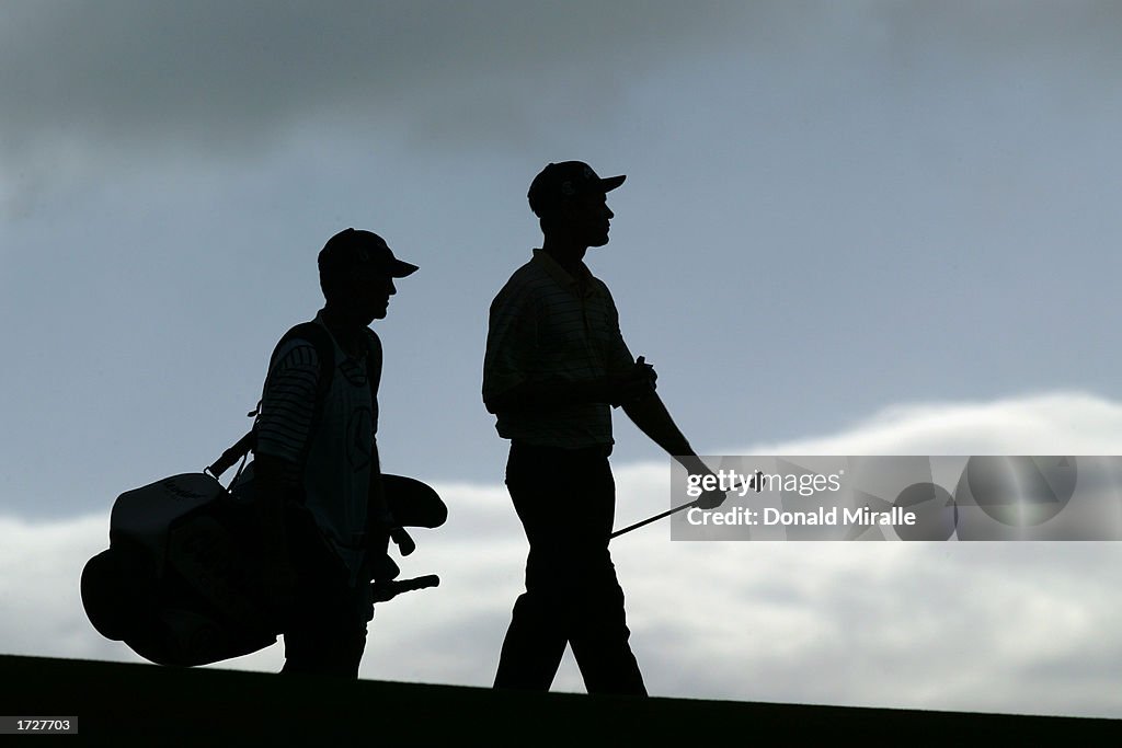 Bob Estes walks with caddie