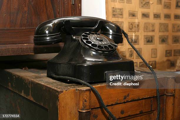 an antique telephone on a wooden table - telephone dial stock pictures, royalty-free photos & images