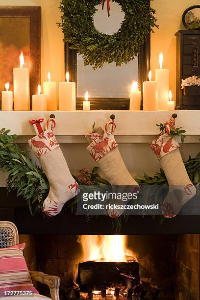 three socks stuck on christmas fireplace - stockings stock pictures, royalty-free photos & images