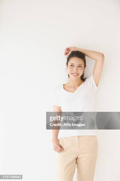 portrait of young japanese woman in a white room - v neck stock-fotos und bilder